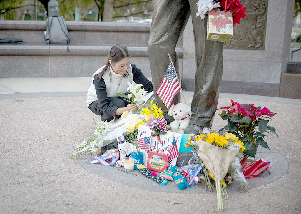 A mourner leaves a card and flowers at a makeshift memorial in tribute to former US President George H. W. Bush at a monument in his honor in Houston, Texas, on December 2, 2018.