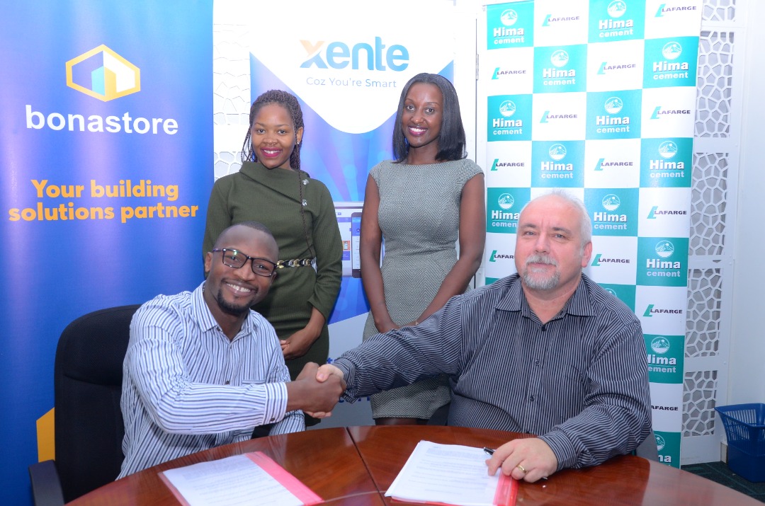 Francis Nkurunungi, Xente’s Chief Operations Officer (Seated L) and Paul Bernard Kelly (Seated R), Hima Cement’s Retail Manager shake hands after signing a Memorandum of Understanding to open an online shopping platform where Hima Cement and building solutions provider, bonastore Uganda will now avail their products to customers online. Looking on are Christine Kyokunda, Marketing Officer at Hima Cement and Lyn Tukei, Chief Marketing and Communications Officer, Xente