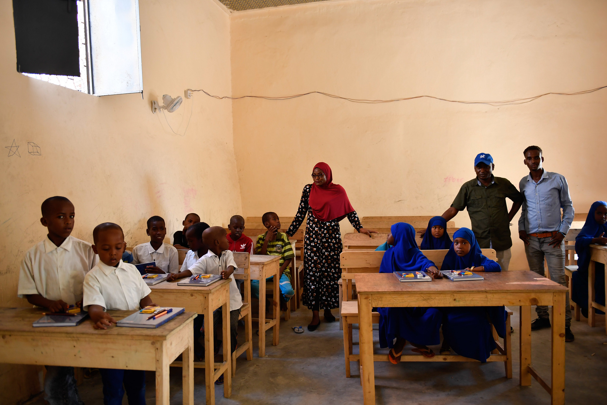 Ulrike Kahbila Mbuton, the AMISOM Human Rights Officer, stands amongst pupils at Qamar Primary School, after the AMISOM team donated an assortment of stationery to the school in Mogadishu on 19 December 2019. The school was renovated by AMISOM following several terrorist attacks in Mogadishu that destroyed it, leading to its closure in 2016. AMISOM Photo / Omar Abdisalan