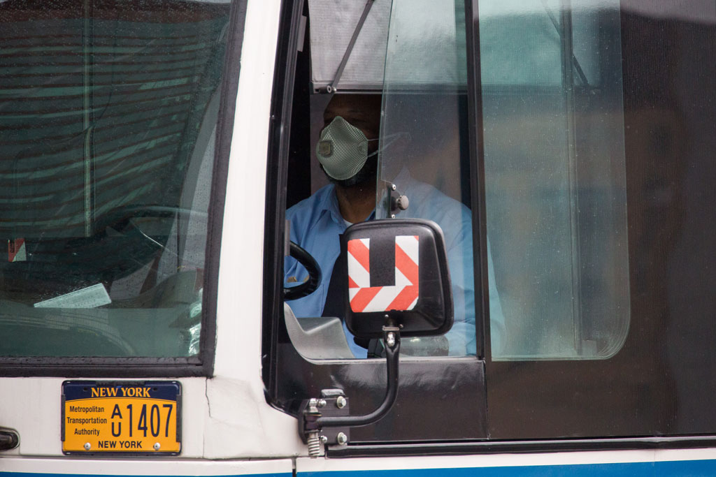 A bus driver wearing a face mask steers in the Brooklyn borough of New York, the United States, on April 3, 2020. (Photo by Michael Nagle/Xinhua)