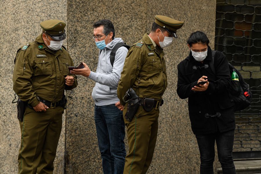 Police check people's paperwork in Santiago, Chile, March 27, 2020. Chile has adopted a "progressive quarantine" to help control the spread of the disease in the country. (Photo by Jorge Villegas/Xinhua)