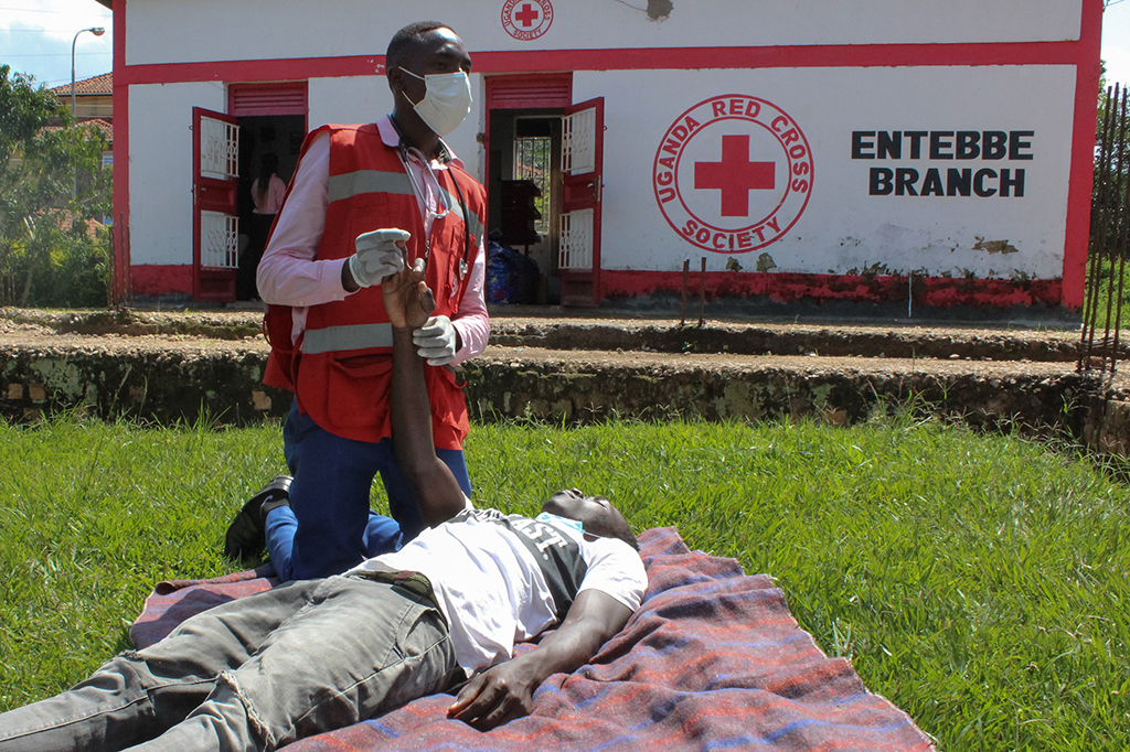 Richard Kabunga (kneeling), who works with the Red Cross, demonstrates a basic life support technique with help from Nasaga Sharif.