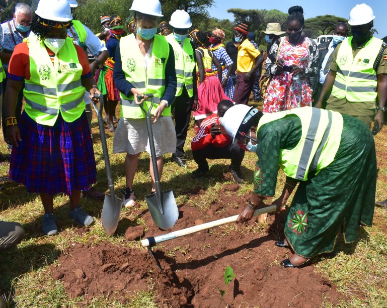 Minister Kitutu plants a tree shortly after the ground breaking ceremony