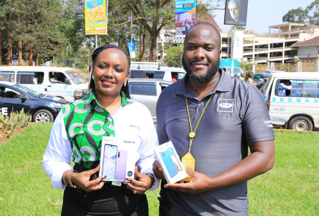 M-KOPA's Brenda Nambalirwa (L) and MTN Uganda's Ian Mugambe display some of the phones that people can access and pay for in installments while enjoying free daily MTN data for a year (1)