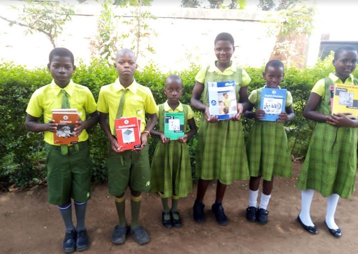 Pupils from Bridge Schools Uganda displaying the NCDC approved books