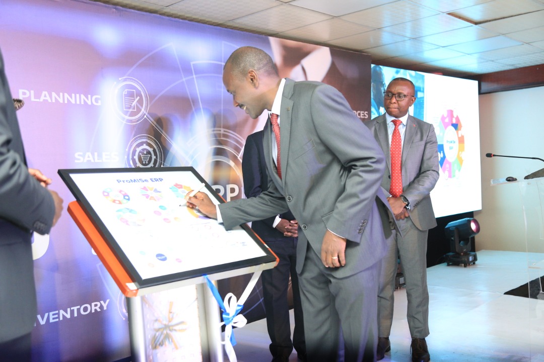 Patrick Kagenda, the Managing Director of Data Care (U) Ltd signs the ProMISe ERP placard during the  launch and 16 year anniversary at Hotel Africana in Kampala.  ProMISE ERP, a system that swiftly digitizes and automates business processes (PHOTO/Courtesy)