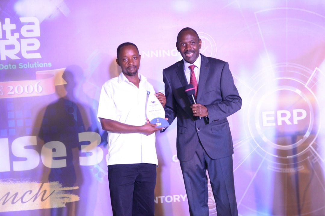 Patrick Kagenda, the Managing Director of Data Care (U) Ltd award Aaron Musana the longest serving staff during the 16 year anniversary at Hotel Africana in Kampala. ProMISE ERP, a system that swiftly digitizes and automates business processes (PHOTO/Courtesy).