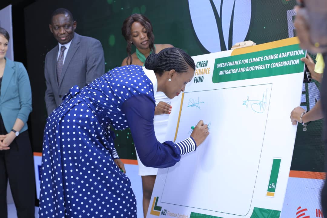 Ms. Mona Muguma Ssebuliba, the CEO aBi Finance, signs a board to signify the launch of the Green Finance Fund and Green Taxonomy worth Ugx.124 billion, aimed at promoting sustainable growth and resilience of the agricultural sector in Uganda