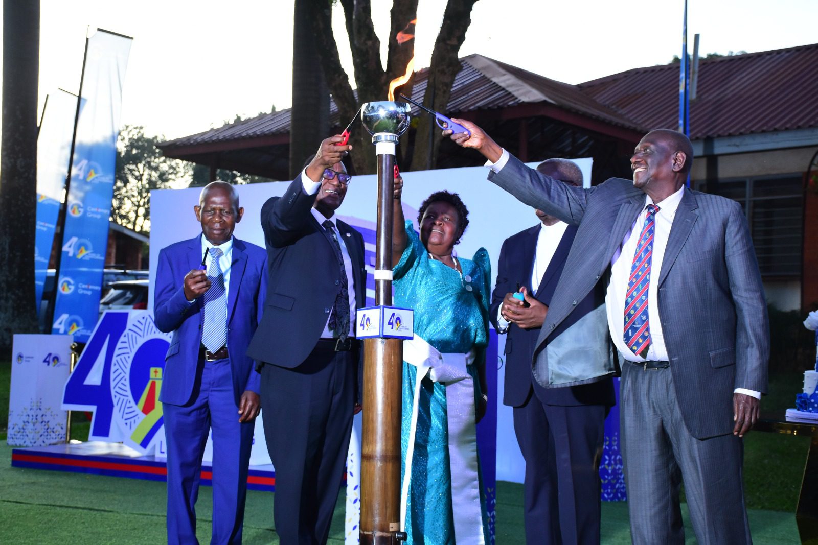 Counsel Simeon Lutaakome one of the Centenary Bank founding members (left), his wife, Prof. Ddumba Ssentamu the Centenary Group Chairman (2nd left), Bishop Joseph Antony Zziwa the Chairman Episcopal Conference and Bwoch Gustav (right) the Chairman Centenary Bank light the candle to symbolize the start of the celebrations to mark 40 years of the Centenary Group.