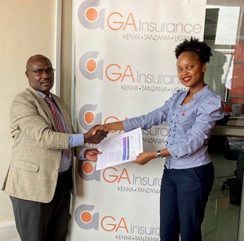 Gordon Asimwe, Marketing Manager GA, Insurance handin over the travel documents to Emily Mahero, the Mayhem Winner at GA Offices.