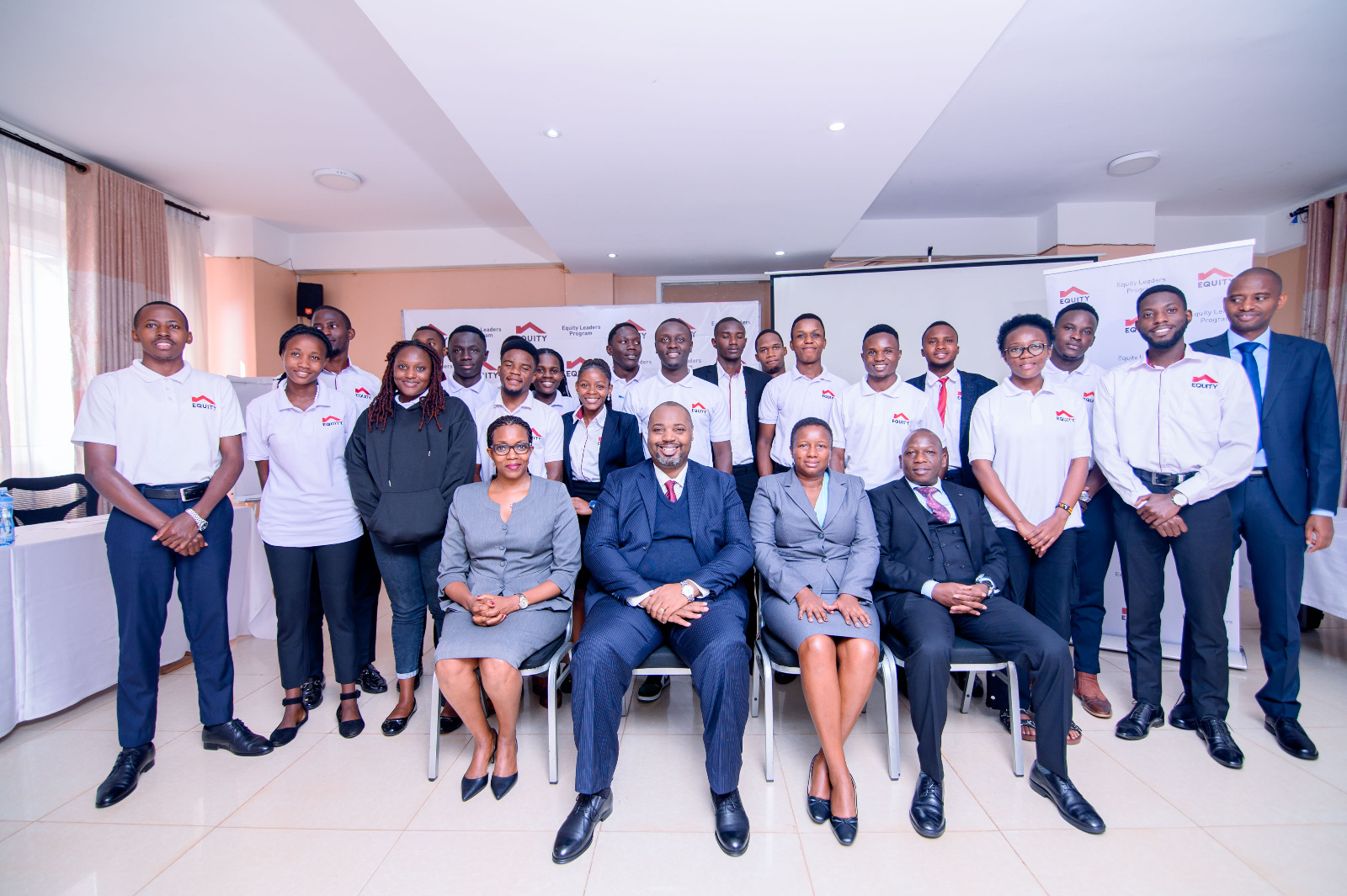 Clare Gatabi Tumwesigye Head Marketing and Corporate Communications, Anthony Kituuka Managing Director, El... and Eliud Njogu from E&M Technologies pose for a group photo with ELP Scholars at Eureka Place Hotel in Ntinda on Tuesday