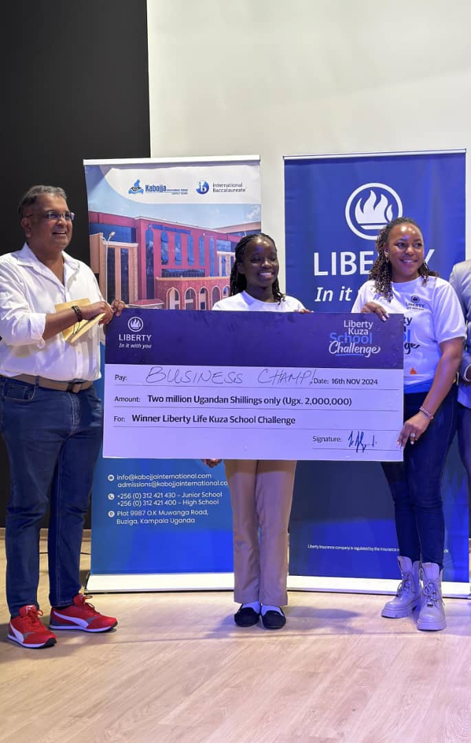 Joseph Almeida (Left), Managing Director of Liberty Life Assurance, and Juliet Murungi (Right), Head of Marketing, present a winning cheque to Jovita Namakula in recognition of her outstanding innovation during the Kuza Challenge handover event at Kabojja International School Kampala.