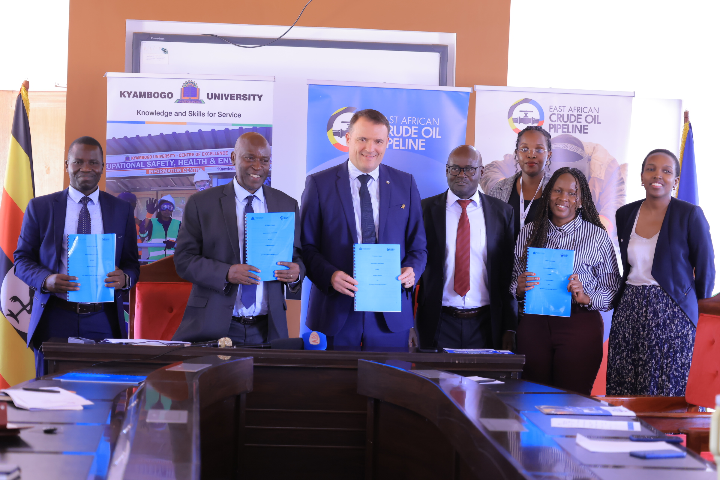 EACOP Managing Director Guillaume Dulout (4th from right) and Kyambogo University Deputy Vice Chancellor Prof. Elly Katunguka (left) seal a new partnership. They're joined by staff from both organizations as they sign a Memorandum of Understanding to drive National Content Capacity Building initiatives.