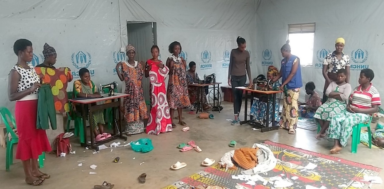 Beneficiaries from Kakoni Women and girls Safe space showing some of their work as others continue to practice tailoring skills.