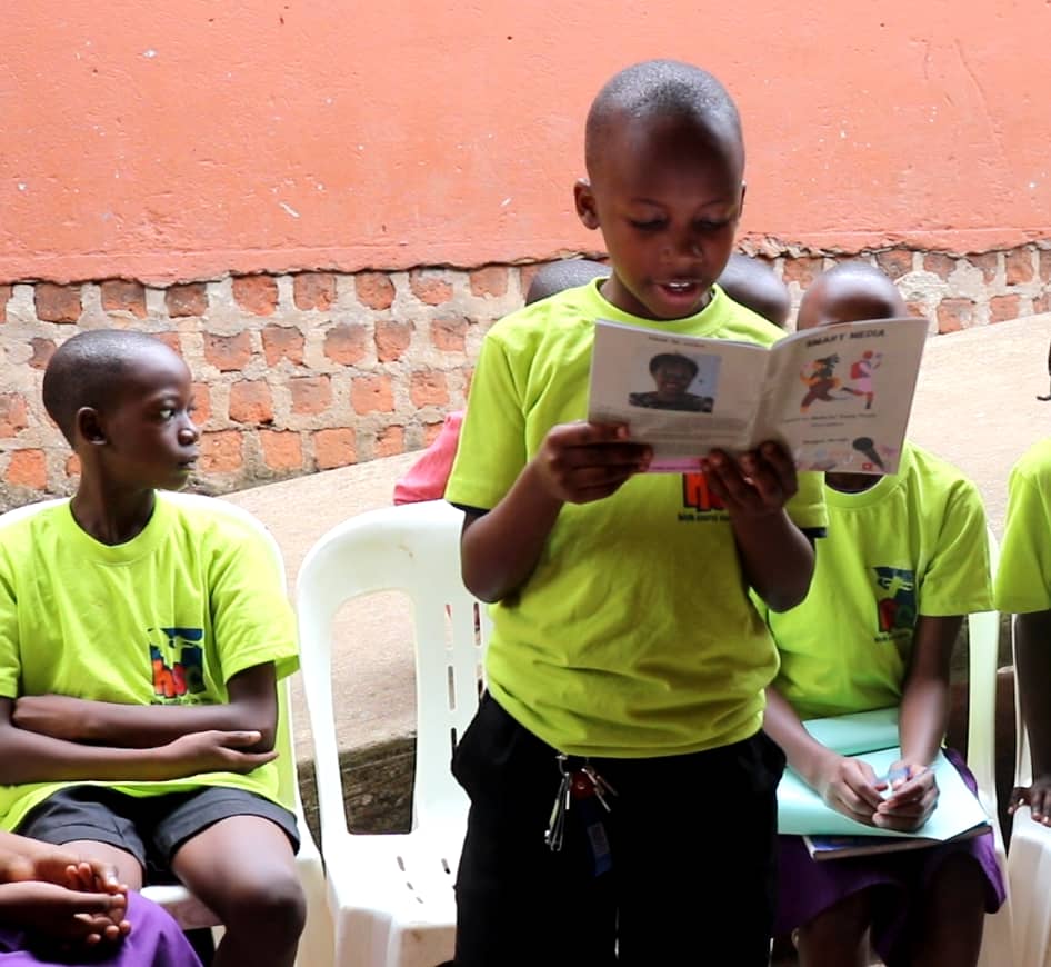 Newly elected Media Club head Hannington Kajja reads from "The Smart Media Guide" during a group session at JesJonny Primary School in Mukono Municipality, Uganda.